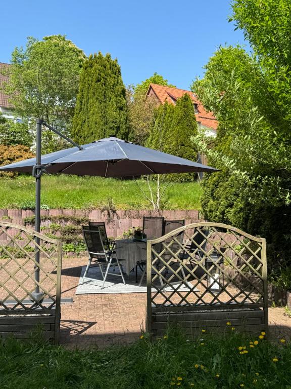 een patio met een parasol en een tafel en stoelen bij FeWo Elisabeth am Harztor in Osterode