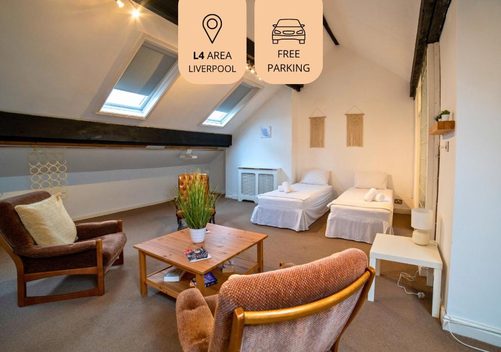 ein Wohnzimmer mit 2 Betten, einem Tisch und Stühlen in der Unterkunft Insurance Stays - Anfield L4 - Spacious house in Liverpool