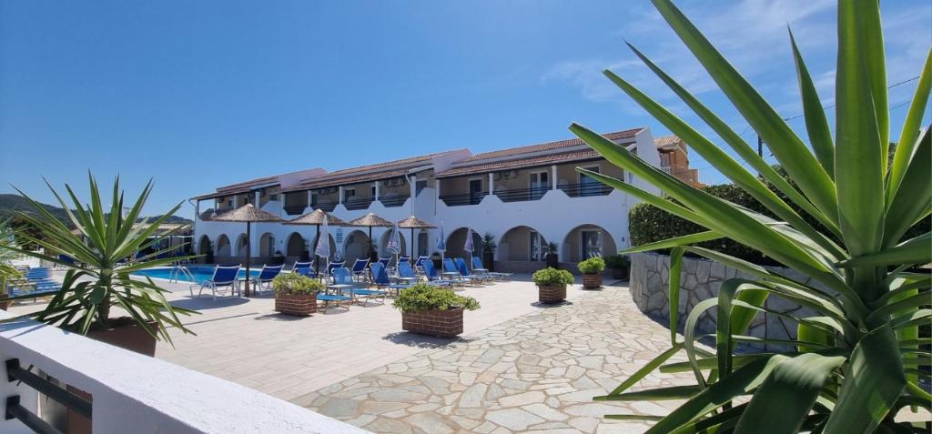 a resort with a pool and chairs and plants at Bardis Sun studios in Arillas