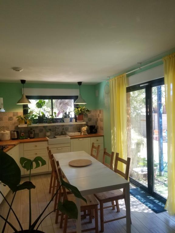 une cuisine avec une table et des chaises dans une pièce dans l'établissement Grande villa 2 min plage - plein centre, à Vias