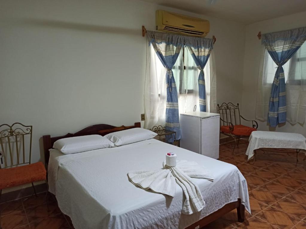 a bedroom with a large white bed and windows at COE RURRENABAQUE in Rurrenabaque