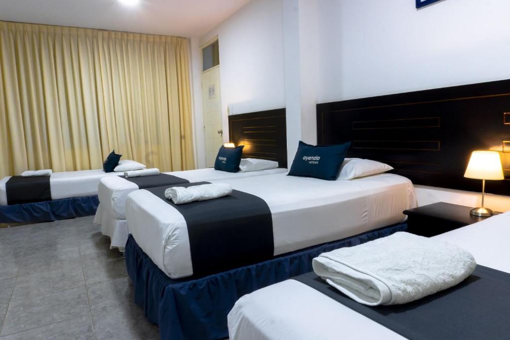 un grupo de 4 camas en una habitación de hotel en Di Costa Hoteles, en Piura