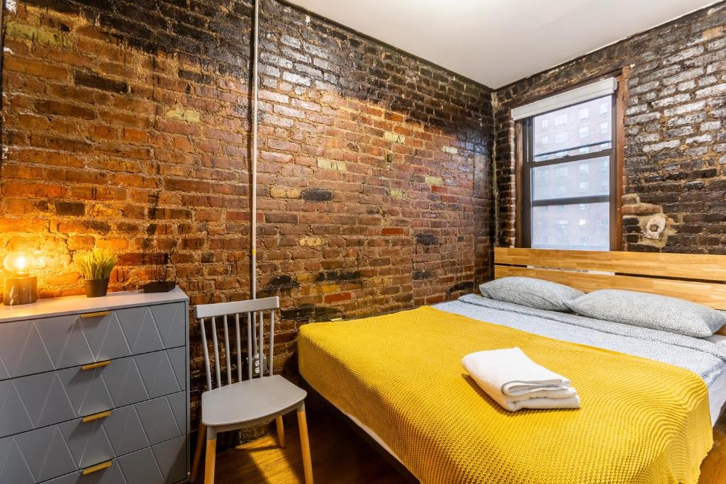 a bedroom with a bed and a brick wall at Heavenly Suites in Perfect Location of Hell Kitchen in New York