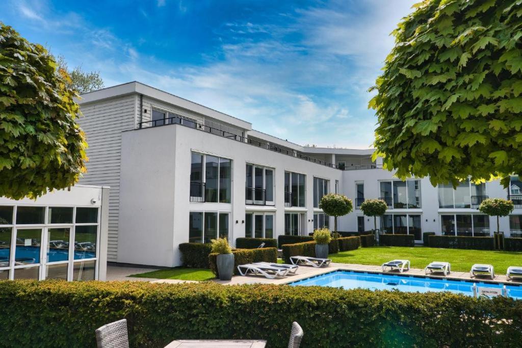 an exterior view of a house with a swimming pool at Hotel de Zeeuwse Stromen - Duinpark in Renesse