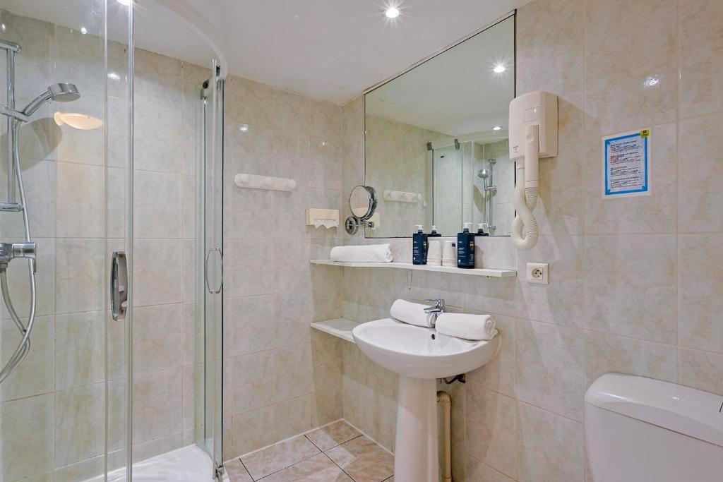 ein Bad mit einer Dusche, einem Waschbecken und einem WC in der Unterkunft Logis Hotel l'Esterella in Agay - Saint Raphael