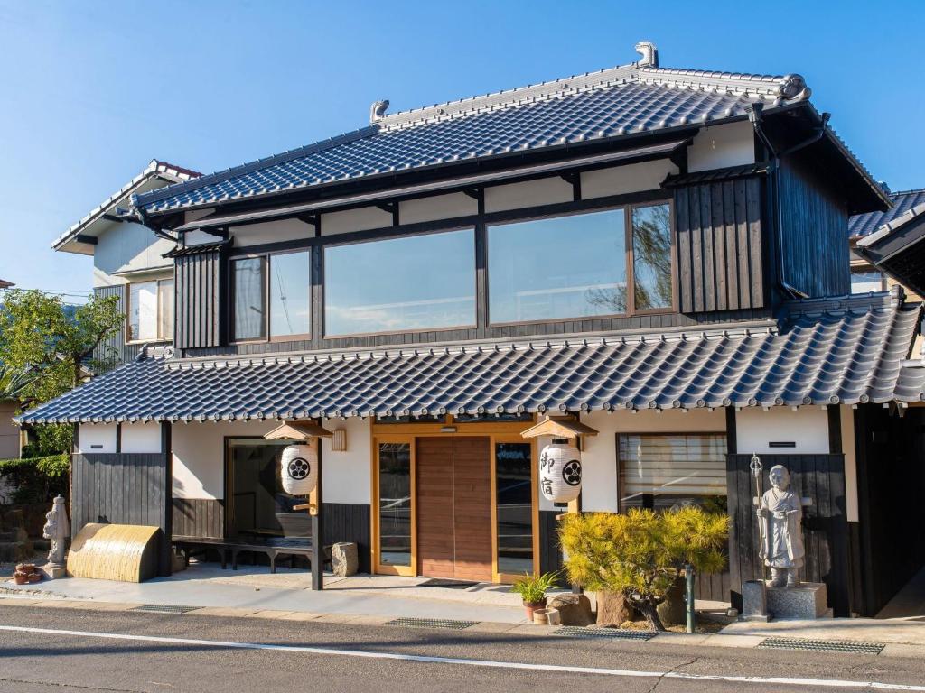 a house with a blue roof on a street at Takayanagi Ryokan - Vacation STAY 88528v in Takamatsu