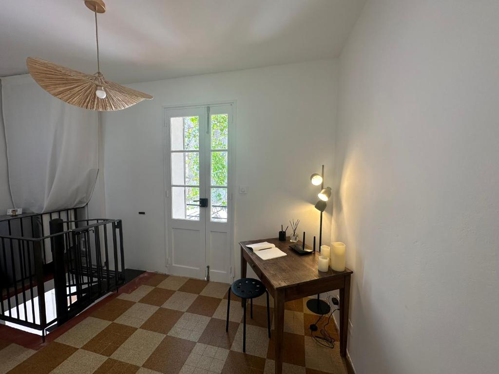 um quarto com uma mesa e uma janela e uma janela em Maison avec patio proche place des Carmes em Avignon