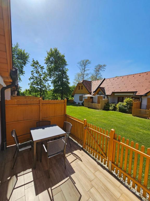 a patio with a table and chairs and a fence at Apartma Trobentica 23 in Moravske-Toplice