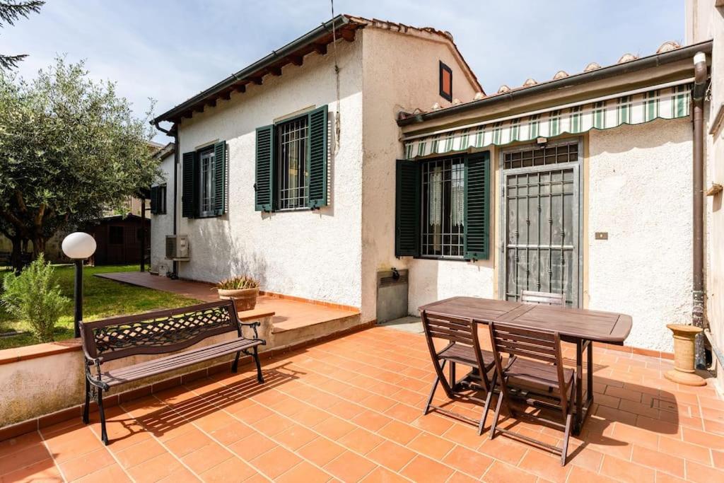a patio with a wooden table and benches in front of a house at Casa Luana San Concordio - Affitti Brevi Italia in Lucca