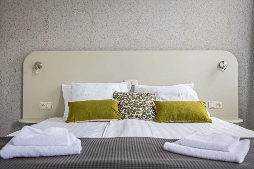 uma cama com toalhas verdes e brancas em Hotel 1711 em Valkenburg