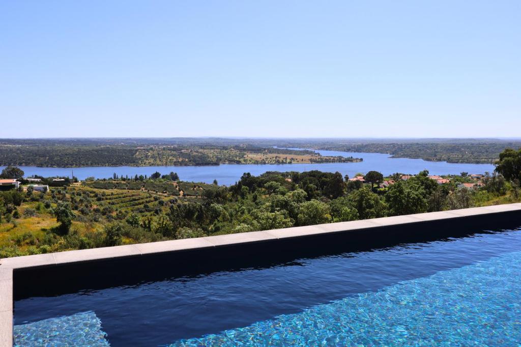 a swimming pool with a view of a river at Caju Villas Montargil - Villa Vale Vilão in Montargil