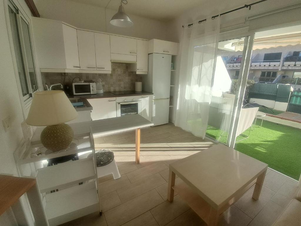 een keuken met witte kasten en een tafel en een raam bij Pool Terrace in El Médano