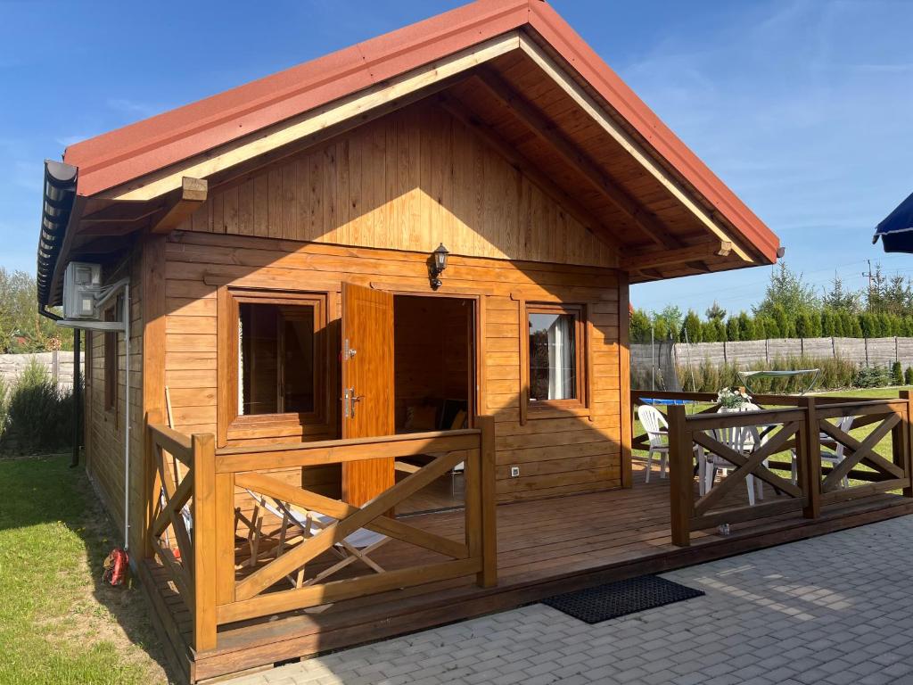 a large wooden dog house with a porch at Domki caloroczne Przytulisko na Mazurach in Ruciane-Nida