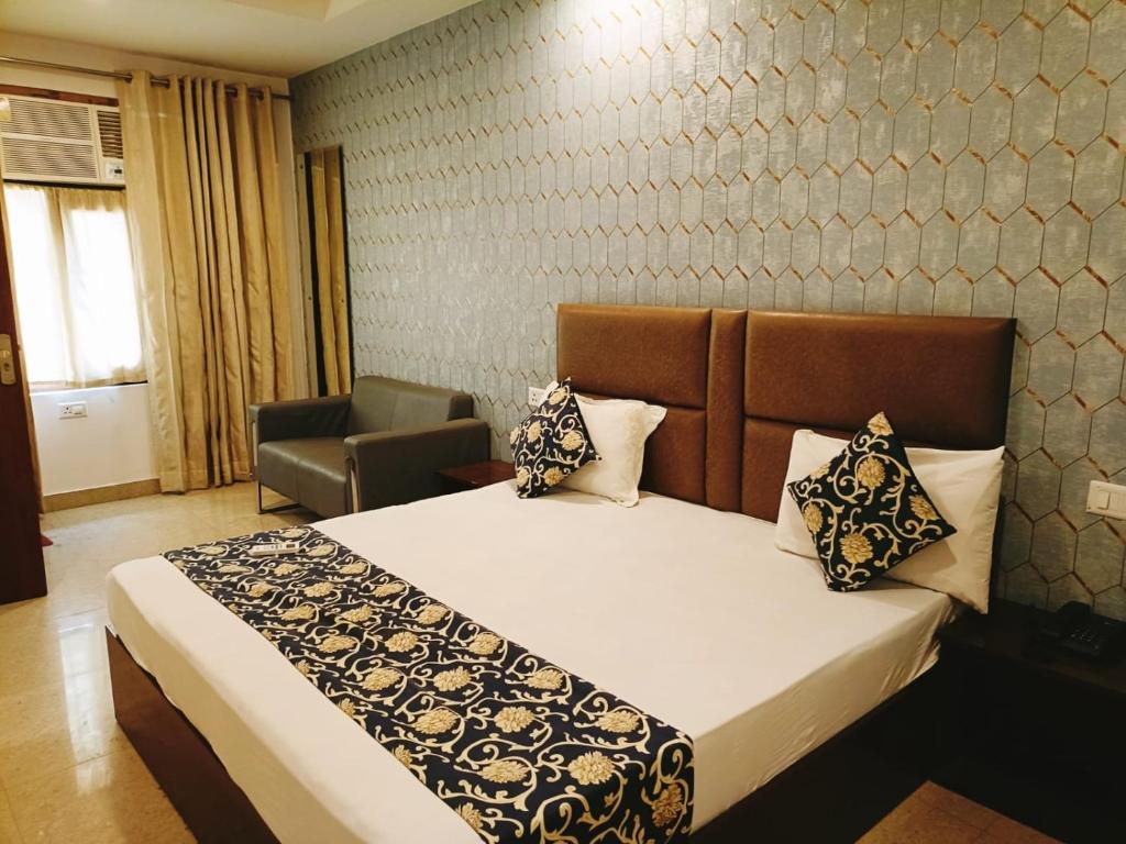 um quarto com uma cama e uma cadeira em Hotel Ambience Palace Near IGI Airport Delhi em Nova Deli