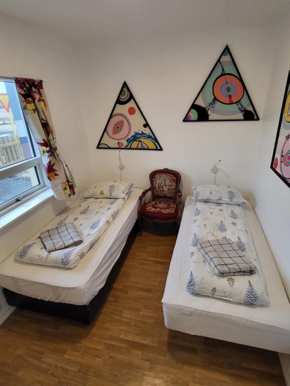 2 camas en una habitación con pinturas en la pared en The Bookstore Family Apartment, en Hellissandur