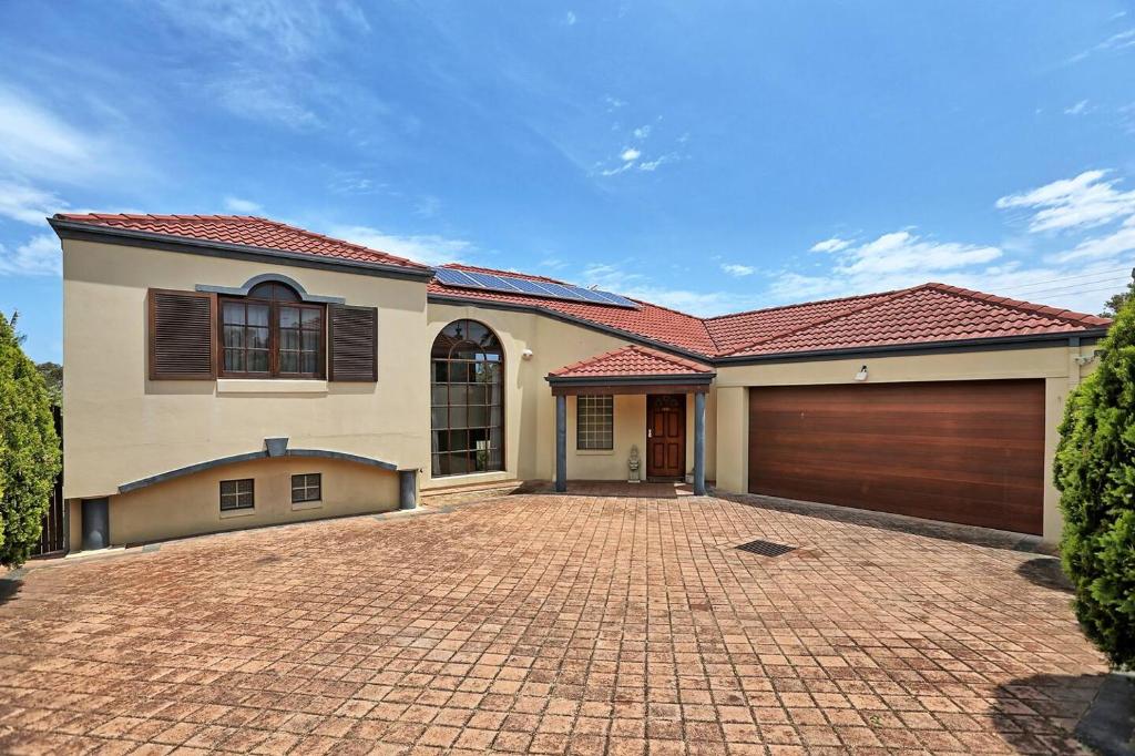 a house with a brick driveway in front of a garage at Rancho Relaxo - Great For Longer Stays! Free Wifi in Perth