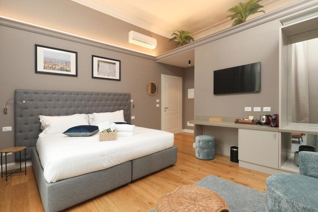 フィレンツェにあるN7 Roomsのベッドルーム1室(ベッド1台、壁にテレビ付)