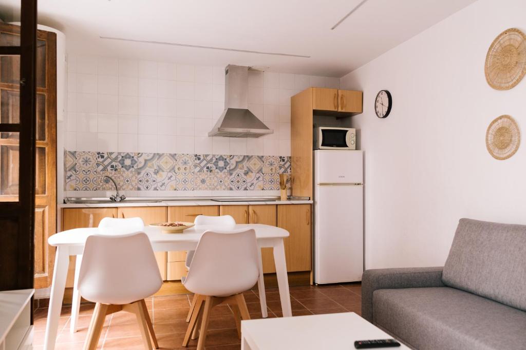 eine Küche und ein Wohnzimmer mit einem Tisch und Stühlen in der Unterkunft Casa Ochavada in Archidona