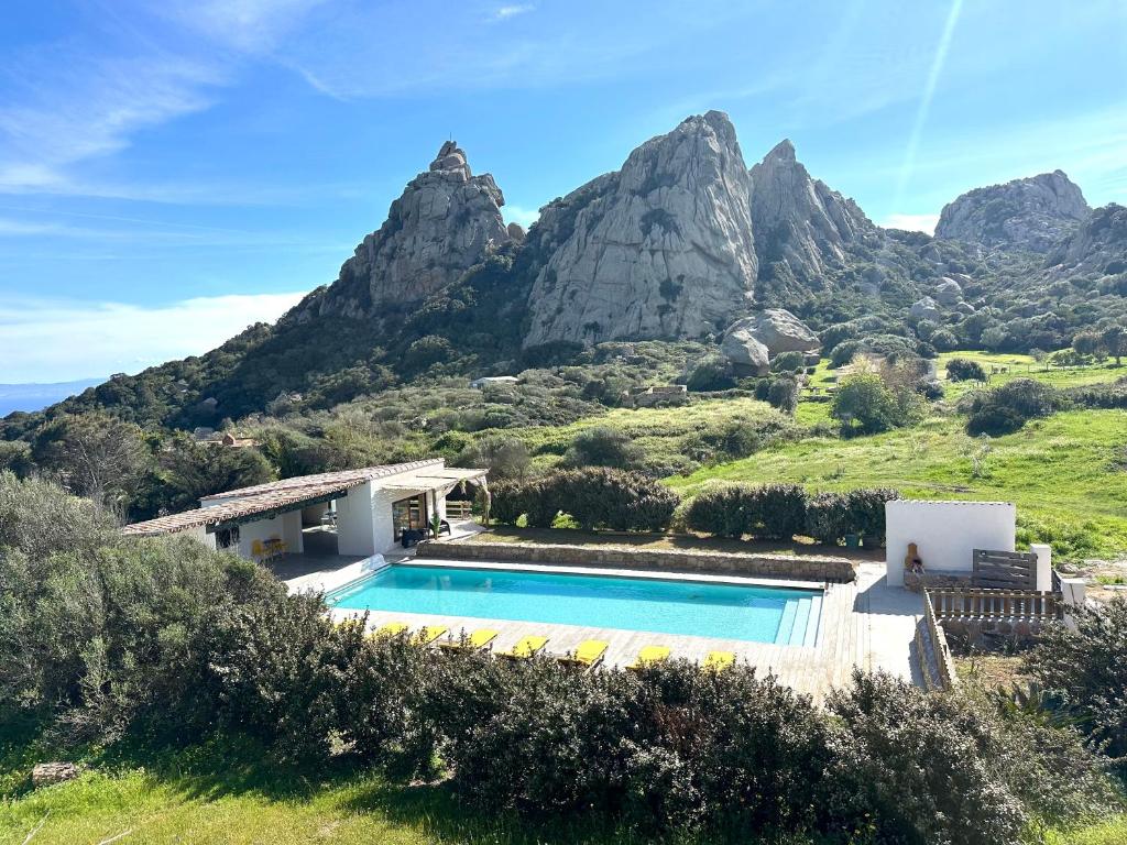a villa with a swimming pool in front of a mountain at A Santa Trinita in Bonifacio