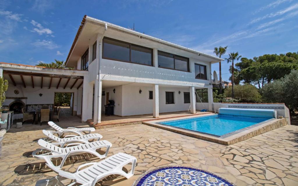 una casa con piscina e sedie a sdraio di Villa con piscina privada y barbacoa - ALBERT VILLAS Alcossebre ad Alcossebre