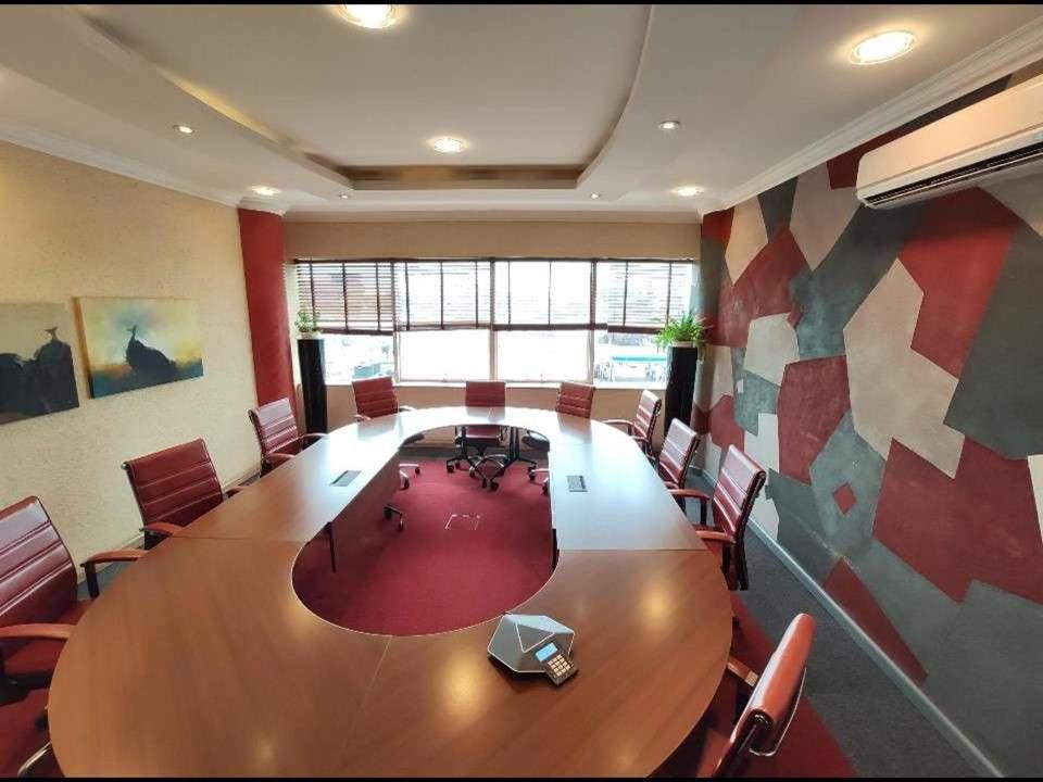 une grande salle de conférence avec une grande table et des chaises en bois dans l'établissement Park Place Business Center, à Nairobi
