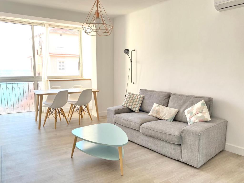 ein Wohnzimmer mit Sofa und Tisch in der Unterkunft L'Ajax Appartement T3 centre et Bord de mer in Ajaccio