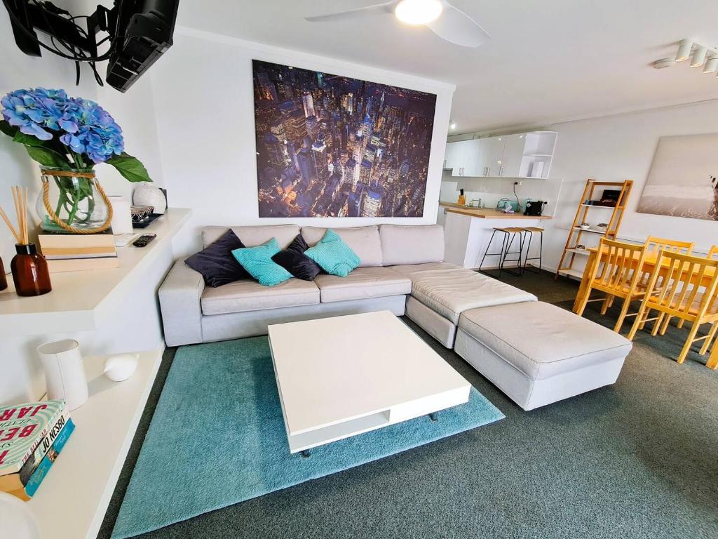 a living room with a couch and a table at Chic 2 Bed Apartment On Scarborough Beach in Perth