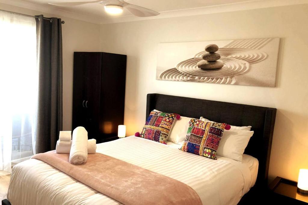 a bedroom with a bed with white sheets and pillows at West Beach Lagoon 123 - Location & Views!!! in Perth