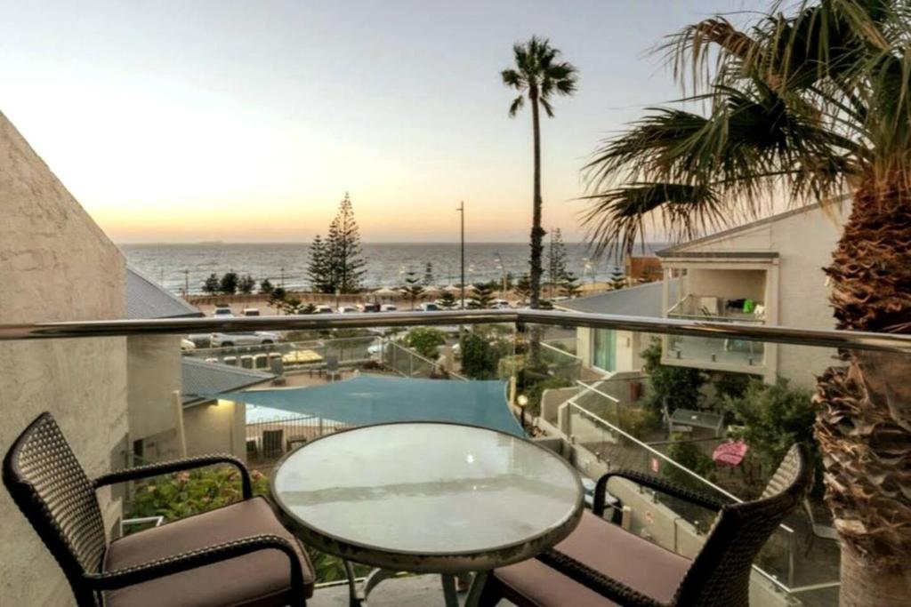 balcone con tavolo, sedie e vista sull'oceano di Sunset On Esplanade a Perth