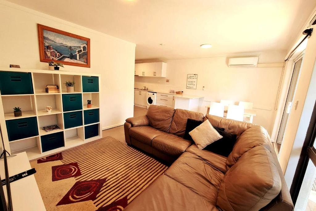 a living room with a brown couch and a rug at West Beach Lagoon 206 - Sleeps Three! Value!!! in Perth