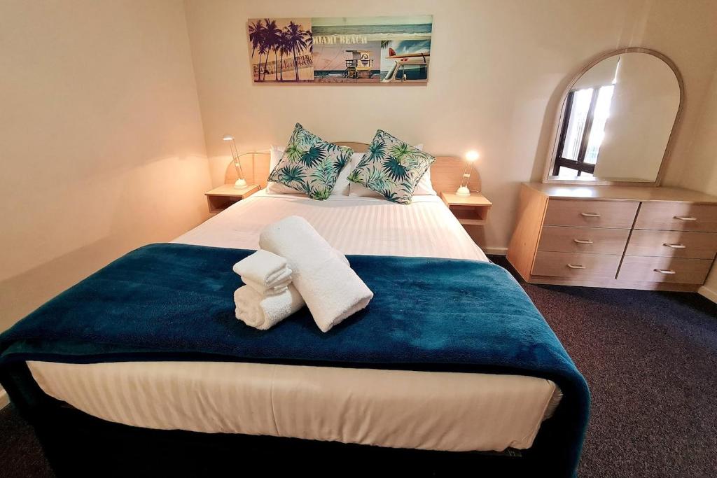 a bedroom with a large bed with towels on it at West Beach Lagoon 202 - Quiet & Ground Floor! in Perth