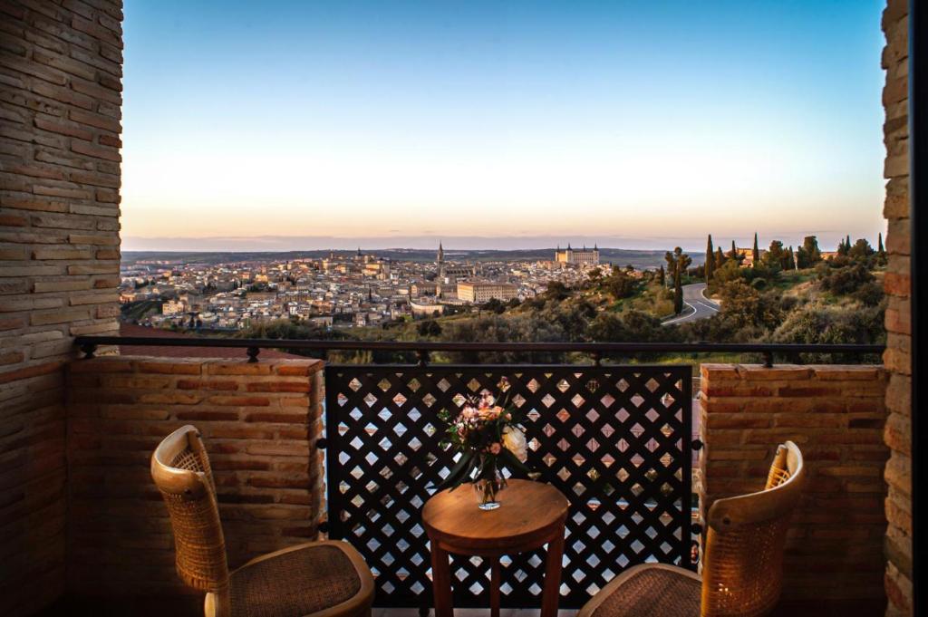 d'une table et de chaises sur un balcon avec vue. dans l'établissement Hotel Cigarral Santa María, à Tolède