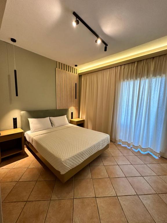 a bedroom with a bed and a large window at Semiramis in Lefkada Town