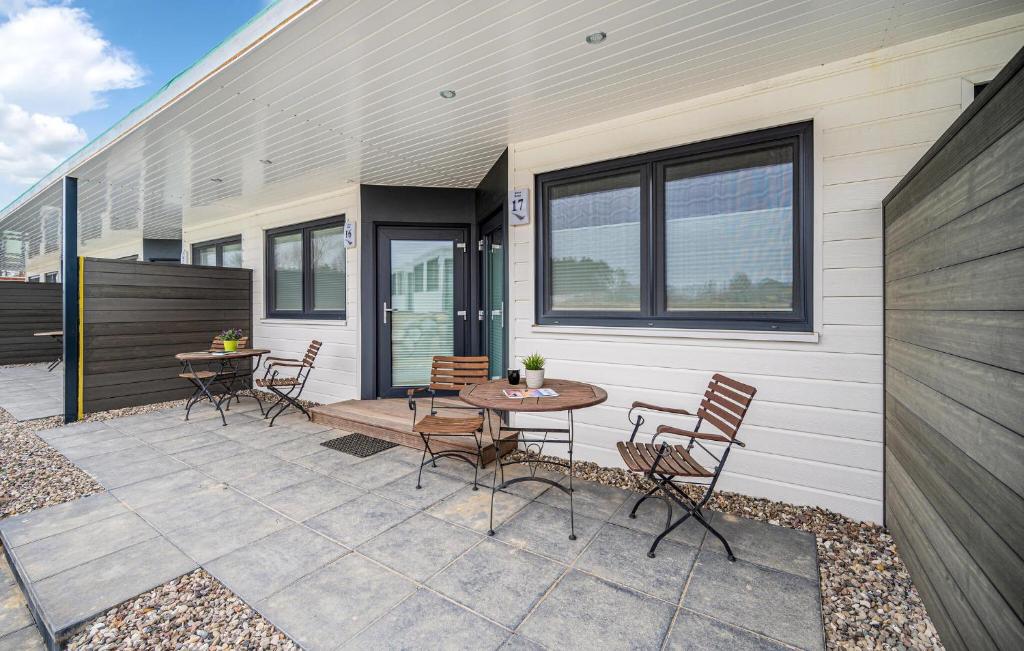 a patio with chairs and a table next to a building at Apartments Waterfront in Sagard