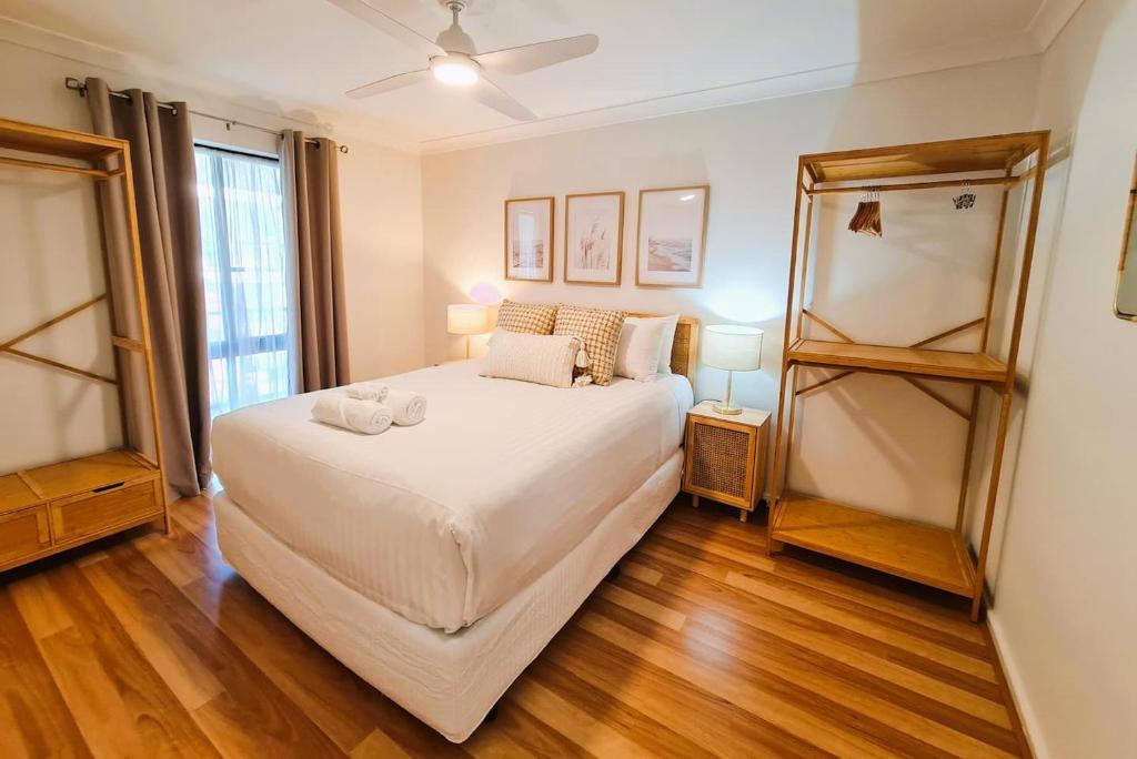 sypialnia z dużym białym łóżkiem i drewnianą podłogą w obiekcie Beach Break Iconic Scarborough w mieście Perth