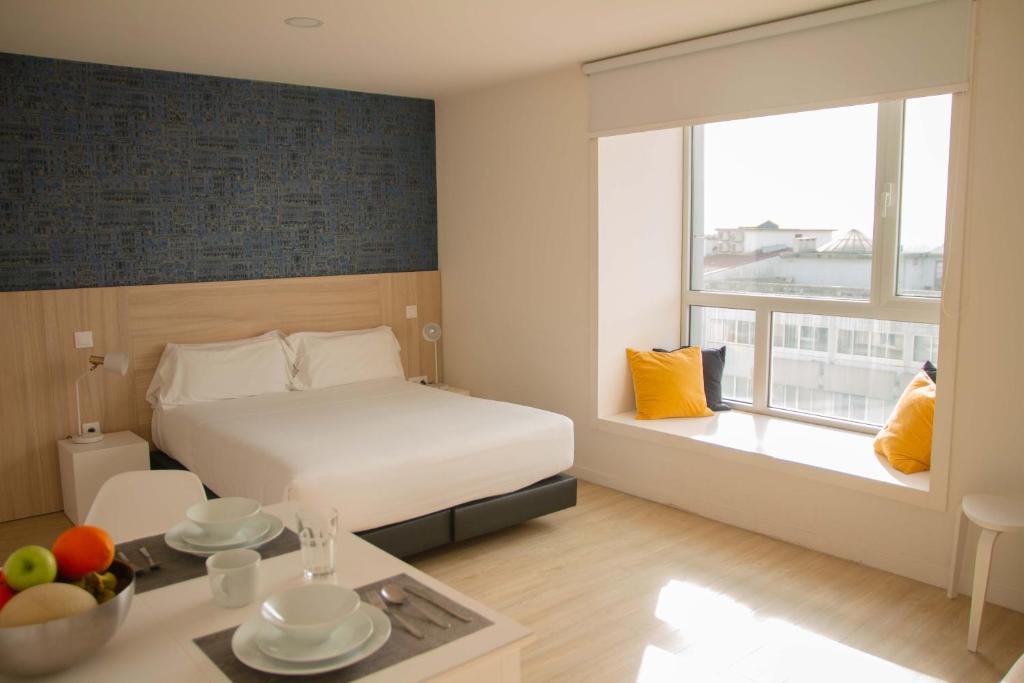 una camera d'albergo con un letto e un tavolo con frutta di room Select Porto Suites a Porto