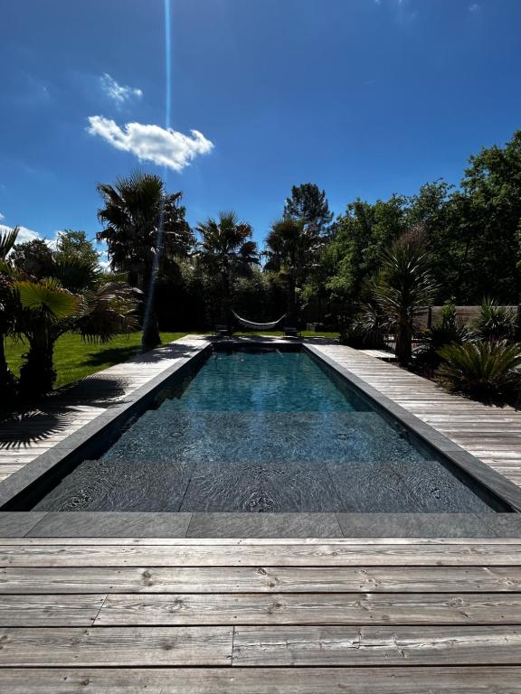 una piscina en medio de un patio en Villa aux Palmiers,Piscine 28°,Pétanque,Coeur Bassin, en Audenge