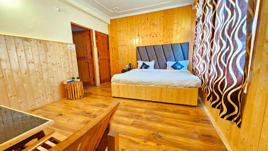 - une chambre avec un lit dans une pièce dotée de murs en bois dans l'établissement The Suraj lodge, Hadimba Road Manali, à Manali