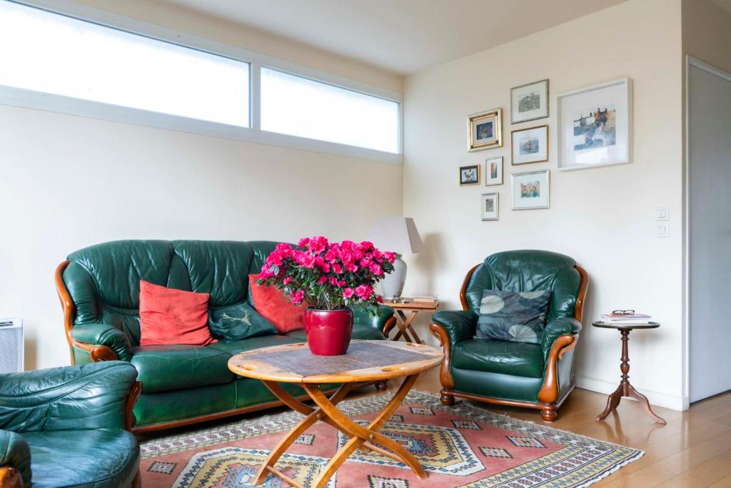 - un salon avec un canapé vert et 2 chaises dans l'établissement Charming duplex with two balconies in the 13th, à Paris