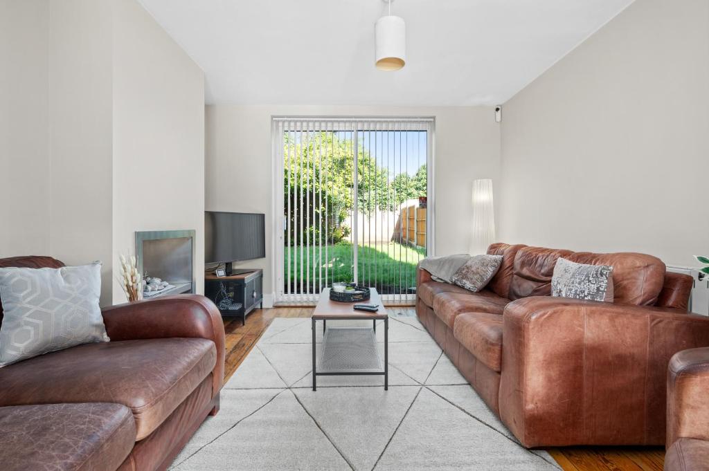 a living room with two brown couches and a table at Fantastic, modern 3 bedroom house in Manchester
