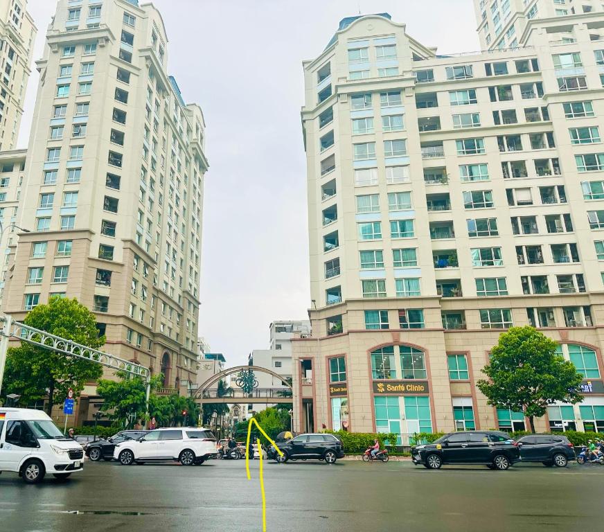 a city street with cars and tall buildings at Dragonfly Village in Ho Chi Minh City
