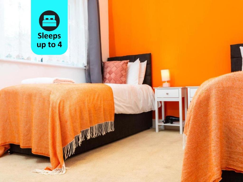 a bedroom with a bed with an orange wall at Modern Apartment -Ipswich - Great Location in Ipswich