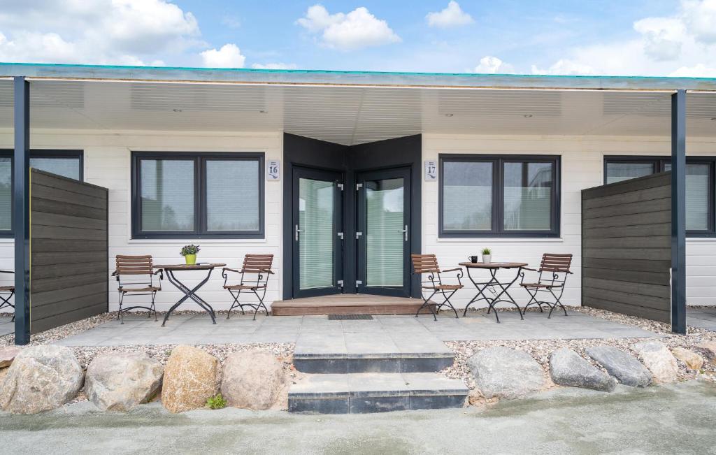 una casa con sillas y mesas delante de ella en Apartments Waterfront, en Sagard