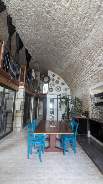 une salle à manger avec une table et des chaises bleues dans l'établissement Maison atypique bord de l'Yonne, à Cravant
