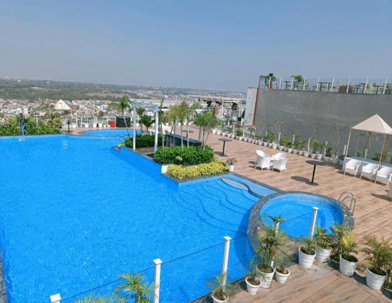 a large blue swimming pool on top of a building at The Grand hotel and suites studio M Leo in Jaipur