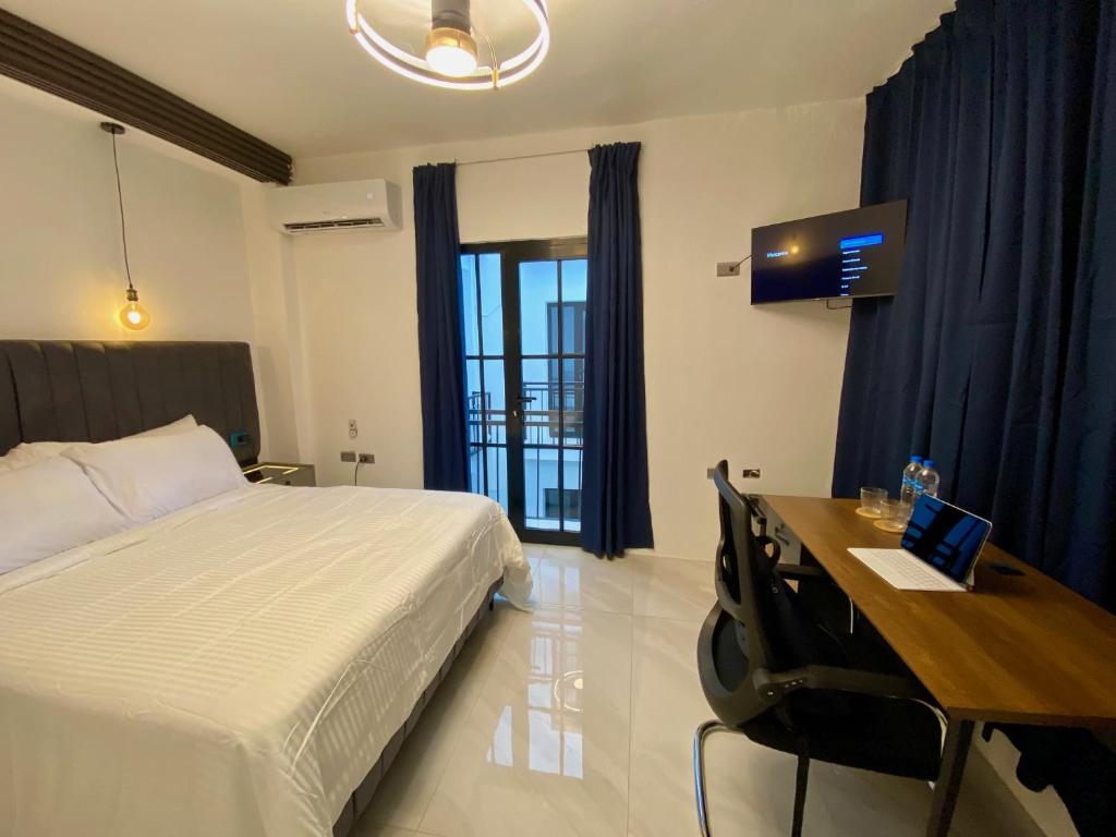 1 dormitorio con 1 cama y escritorio con ordenador portátil en RIG Colonial Experience en Santo Domingo