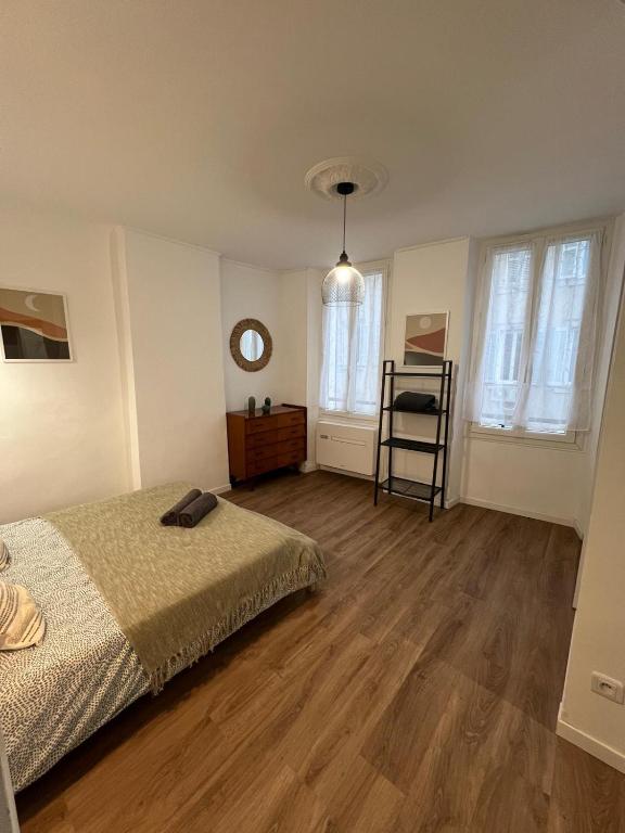 een slaapkamer met een bed en een houten vloer bij Le Decazes, Séjournez à deux pas de la plage in Marseille