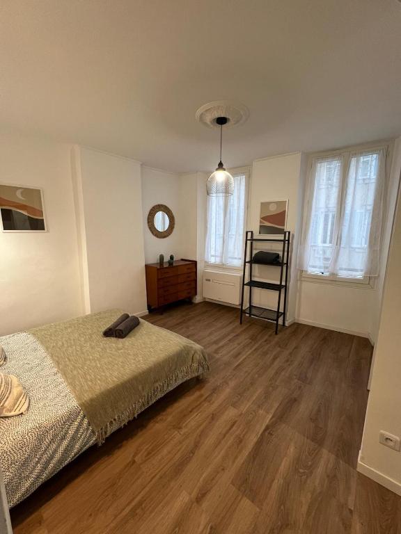une chambre avec un lit et un parquet dans l'établissement Le Decazes, Séjournez à deux pas de la plage, à Marseille