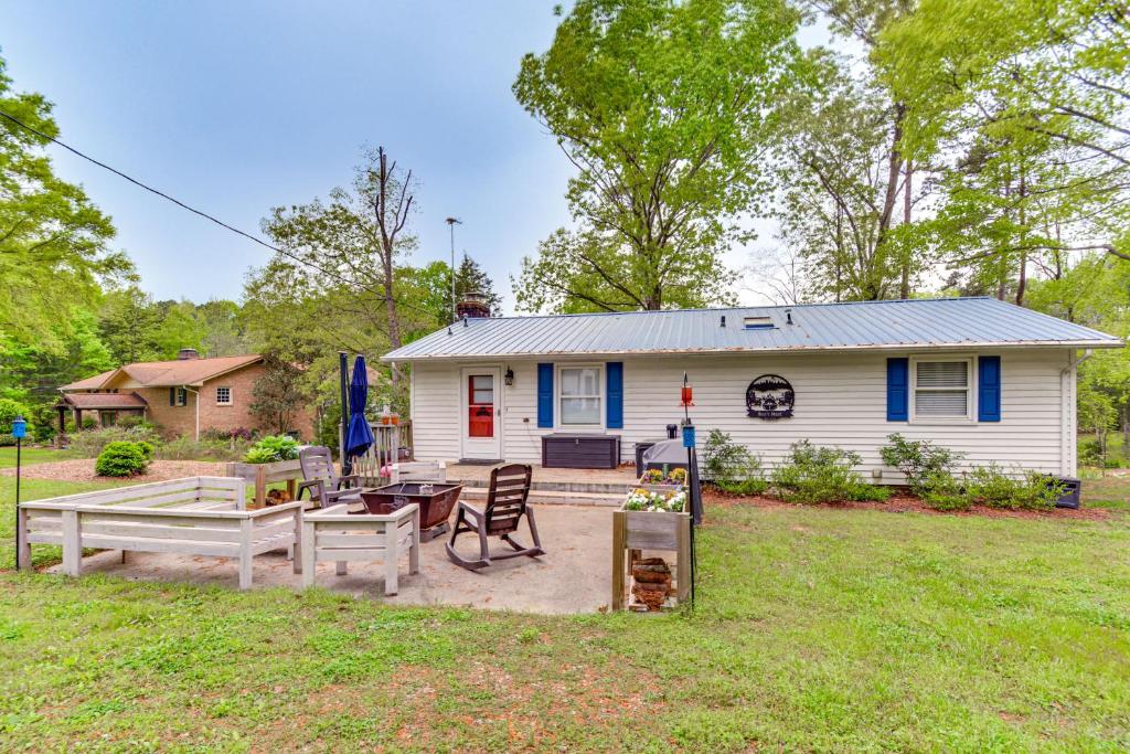 a white house with a table and chairs in the yard at Lakefront Leasburg Home with Dock and Views! in Leasburg