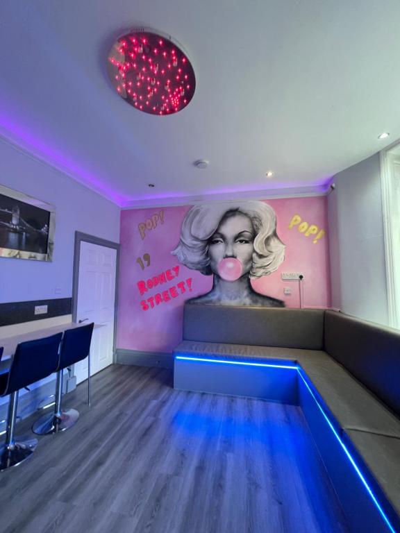 una stanza con un divano e un dipinto di una donna di 19 Rodney Street Apartments a Liverpool